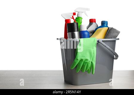 Seau gris avec produits d'entretien pour voiture sur table en bois sur fond blanc Banque D'Images