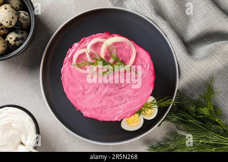 Salade de hareng sous pelage de fourrure sur table gris clair, à plat. Plat russe traditionnel Banque D'Images