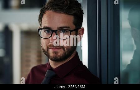 Le visage de l'excellence des affaires. Portrait d'un jeune homme d'affaires confiant debout dans un bureau moderne. Banque D'Images