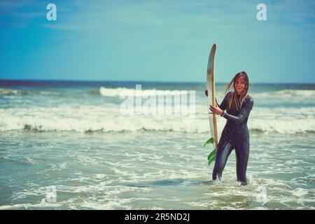 Rien ne se sent aussi bien que le surf. une belle jeune femme qui va faire du surf à la plage. Banque D'Images