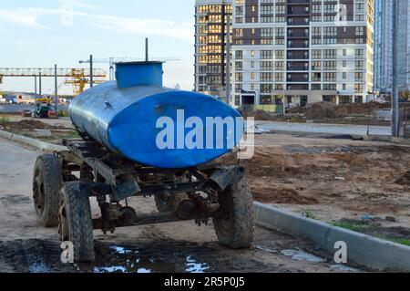 station mobile de distribution d'eau dans le centre-ville. une grande voiture bleue sur roues avec un réservoir plein d'eau la livre aux gens dans des bouteilles et des conteneurs. Banque D'Images