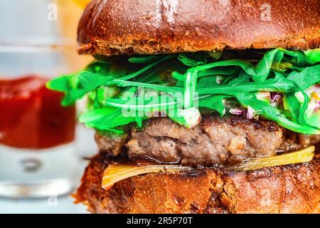 Un hamburger de bœuf juteux avec un petit pain frais, une généreuse portion de légumes et de fruits pour créer un repas malsain et délicieux. Banque D'Images