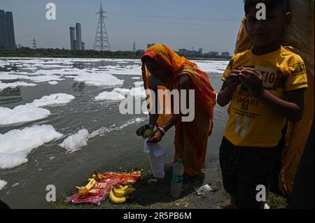 New Delhi, Delhi, Inde. 5th juin 2023. Une femme recueille ses articles rituels après avoir effectué un rituel hindou sur les rives de la rivière Yamuna recouvert de mousse toxique causée par les rejets industriels, à la Journée mondiale de l'environnement, à New Delhi, Inde sur 5 juin 2023. La Journée mondiale de l'environnement est la Journée des Nations Unies pour encourager la sensibilisation et les actions mondiales en faveur de la protection de l'environnement. (Credit image: © Kabir Jhangiani/ZUMA Press Wire) USAGE ÉDITORIAL SEULEMENT! Non destiné À un usage commercial ! Crédit : ZUMA Press, Inc./Alay Live News Banque D'Images