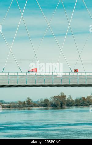 Semi-camion rouge traversant le pont sur le Danube à Novi Sad le jour ensoleillé du printemps Banque D'Images