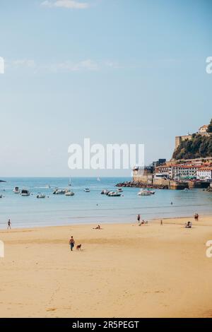 Foule de personnes appréciant des vacances d'été sur la plage de sable de la Concha contre des immeubles d'appartements le jour ensoleillé à Donostia San Sebastian, pays Basque, S Banque D'Images