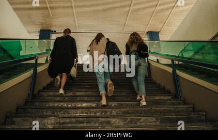 Vue arrière de trois filles marchant à l'étage vers la gare. Ils portent des sacs et font un petit voyage Banque D'Images