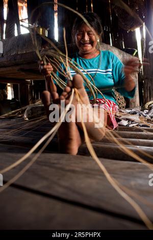 Une des femmes aînées Oro Win aime tisser un panier de vignes forestières, Sao Luis Indian Post, bassin de l'Amazone, Brésil. Banque D'Images