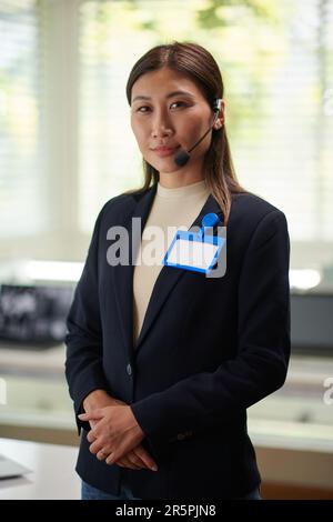 Portrait de l'opérateur du service d'assistance avec un bagde sur une veste debout au bureau Banque D'Images