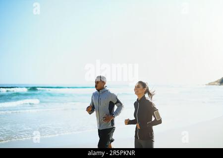 Votre bien-être est important. un jeune couple sportif pour une course le long de la plage. Banque D'Images