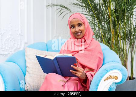 Bonne femme du Moyen-Orient portant de l'abaya à la maison - magnifique portrait de femme adulte musulmane dans l'appartement, des concepts sur la vie domestique et islamique Banque D'Images