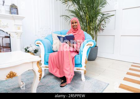 Bonne femme du Moyen-Orient portant de l'abaya à la maison - magnifique portrait de femme adulte musulmane dans l'appartement, des concepts sur la vie domestique et islamique Banque D'Images