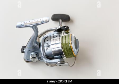 Kiev, Ukraine - 27 janvier 2023 : rabatteur de pêche en acier bleu avec cordon enroulé sur une bobine sur fond blanc. Shimano Technium c'est un outil de pêche pro o Banque D'Images