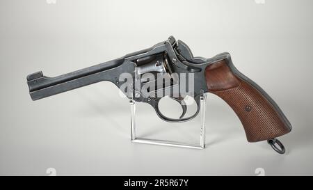 Un revolver vintage sur métal se dresse sur fond blanc. Banque D'Images