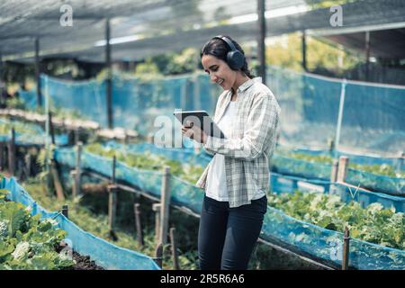 Un travailleur agricole améliore l'équilibre entre vie professionnelle et vie privée en écoutant de la musique et en déplaçant le corps au rythme et au rythme. Conception d'un planning de travail flexible, ta Banque D'Images