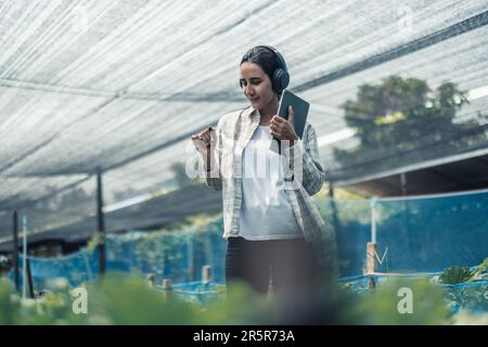 Un travailleur agricole améliore l'équilibre entre vie professionnelle et vie privée en écoutant de la musique et en déplaçant le corps au rythme et au rythme. Conception d'un planning de travail flexible, ta Banque D'Images