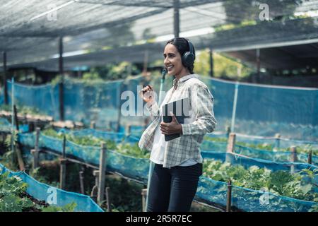 Un travailleur agricole améliore l'équilibre entre vie professionnelle et vie privée en écoutant de la musique et en déplaçant le corps au rythme et au rythme. Conception d'un planning de travail flexible, ta Banque D'Images