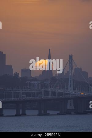 Une vue aérienne stupéfiante d'un paysage urbain avec un ciel jaune vif et un pont qui s'étend devant lui Banque D'Images