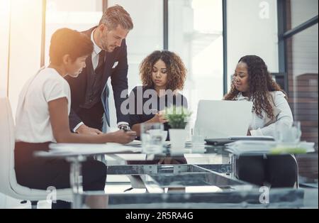 Lorsqu'ils se rencontrent, ils signifient affaires. un groupe de collègues ayant une réunion dans un bureau moderne. Banque D'Images