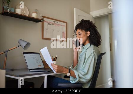 Jeune femme d'affaires parlant au téléphone et lisant des documents Banque D'Images