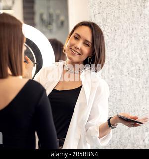 l'artiste maquilleur applique le maquillage du mannequin au salon de beauté avant les vacances Banque D'Images