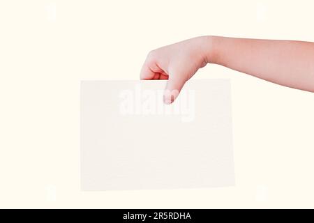 Main tenant un morceau de papier blanc vierge sur un fond solide Banque D'Images