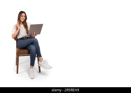 Femme d'affaires assistant à la réunion en ligne. Accueillir des collègues ou des clients. Agitant la main. Souriant, fille joyeuse assise sur la chaise tenant l'ordinateur portable. Banque D'Images