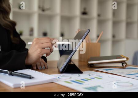gros plan de la main de l'employé à l'aide d'un stylet sur une tablette numérique pour un bénéfice mensuel de l'entreprise lors de l'événement de réunion dans la salle de conférence. stratégie commerciale Banque D'Images
