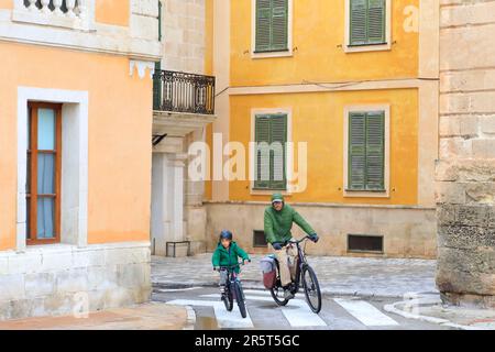 Espagne, Iles Baléares, Minorque, Ciutadella, es Born Square, père et son enfant arrivant en vélo sur la place Banque D'Images