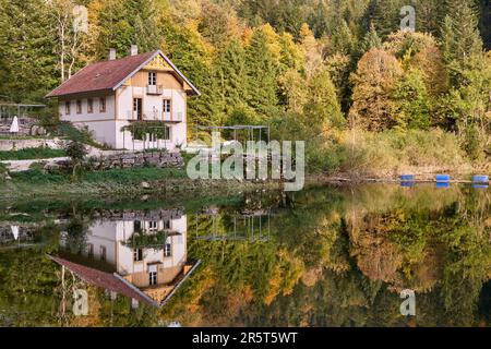 France, Doubs, Villers le Lac, saut du Doubs, extrémité du lac de Chaillexon ou lac des Brenets à la frontière avec la Suisse (canton de Neuchâtel), chalet restaurant sur la rive suisse Banque D'Images