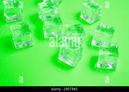 Cubes de glace avec gouttes d'eau dispersées sur l'arrière-plan, vue du dessus. Banque D'Images