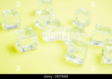 Cubes de glace avec gouttes d'eau dispersées sur l'arrière-plan, vue du dessus. Banque D'Images