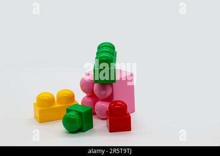 Constructeur de jouets pour enfants lego différentes tailles. Blocs rouge, rose et jaune et vert. Photo de haute qualité. Isolé. Banque D'Images