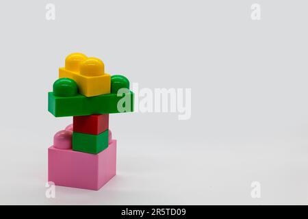 Constructeur de jouets pour enfants lego différentes tailles. Blocs rouge, rose et jaune et vert. Photo de haute qualité. Isolé. Banque D'Images