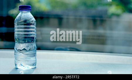 une bouteille d'eau minérale sur le tableau de bord de la voiture. De l'eau embouteillée a été laissée dans la voiture pendant longtemps. Banque D'Images