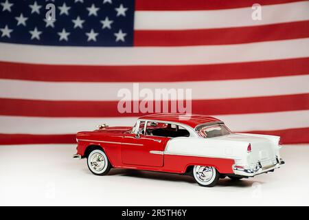 Voiture rouge et blanche 1955 avec un fond de drapeau américain Banque D'Images