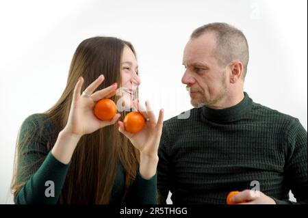 L'homme adulte et la jeune femme choisissent la mandarine et le chou-fleur dans la boutique de légumes. Photo de haute qualité Banque D'Images