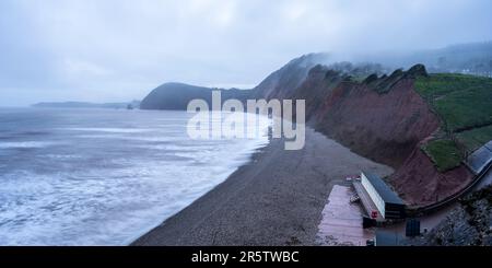 Un nuage bas souffle de la baie de Lyme à la plage d'échelle de Jacob à Sidmouth sur la côte jurassique de Devon est. Banque D'Images