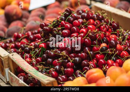 Cerise rouge mûre fraîche ou cerises fruits dans une boîte en bois dans un marché agricole en plein air, alimentation saine saisonnière. Concept de biologique, bio Banque D'Images