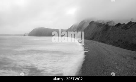 Un nuage bas souffle de la baie de Lyme à la plage d'échelle de Jacob à Sidmouth sur la côte jurassique de Devon est. Banque D'Images