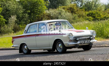 Stony Stratford, Royaume-Uni - 4 juin 2023: 1966 FORD CORTINA voiture classique voyageant sur une route de campagne anglaise. Banque D'Images