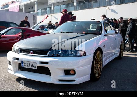 Détail d'une belle voiture de sport japonaise classique, la fabuleuse Nissan Skyline GT-R R33 blanche avec un capot en fibre de carbone noire Banque D'Images