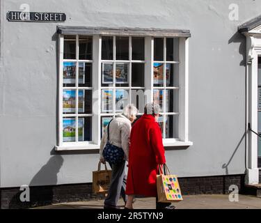 Essex, Royaume-Uni - 24 mars 2023 : deux habitants de la région se promènant devant une fenêtre de magasin sur la rue High, dans la ville de Maldon, dans l'Essex, Royaume-Uni. Banque D'Images