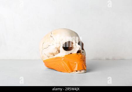 Crâne humain collé sur fond blanc. Concept de censure Banque D'Images