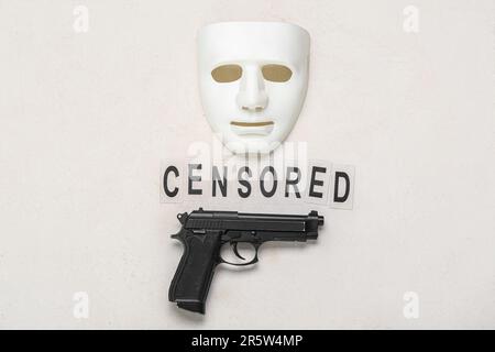 Mot CENSURÉ avec un pistolet et un masque sur fond blanc Banque D'Images