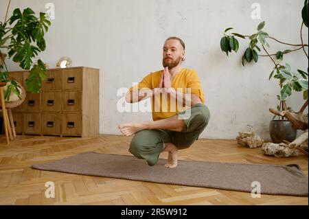 Homme à la coupe forte qui s'équilibre sur une jambe en position de squat Banque D'Images