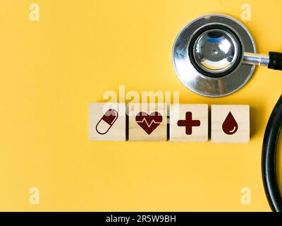 Une rangée de cubes en bois avec des icônes médicales et un stéthoscope. Banque D'Images