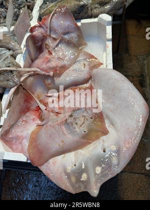 Un assortiment de poissons frais bruts disposés sur un marché, prêt à être acheté Banque D'Images