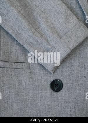 Veste de costume grise pour femme avec boutons de fermeture. Vêtements professionnels ou formels. Tissu gris pour plus de style. Le tissu de costume gris à fines rayures. Texture de la laine Banque D'Images