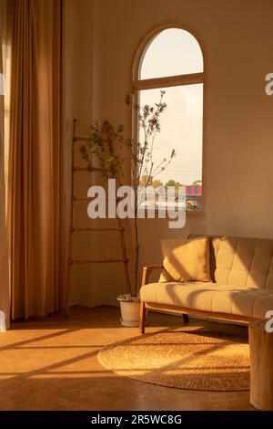 Une ambiance intérieure d'un salon confortable avec une grande fenêtre en arche Banque D'Images