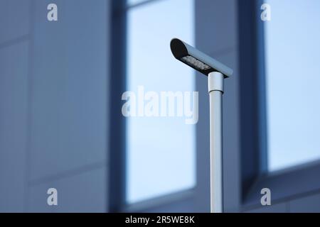 Vue à faible angle de l'éclairage urbain LED moderne sur l'arrière-plan du centre des bureaux urbains. Les LED permettent d'économiser de l'énergie électrique. Concept de technologie d'éclairage de rue. W Banque D'Images